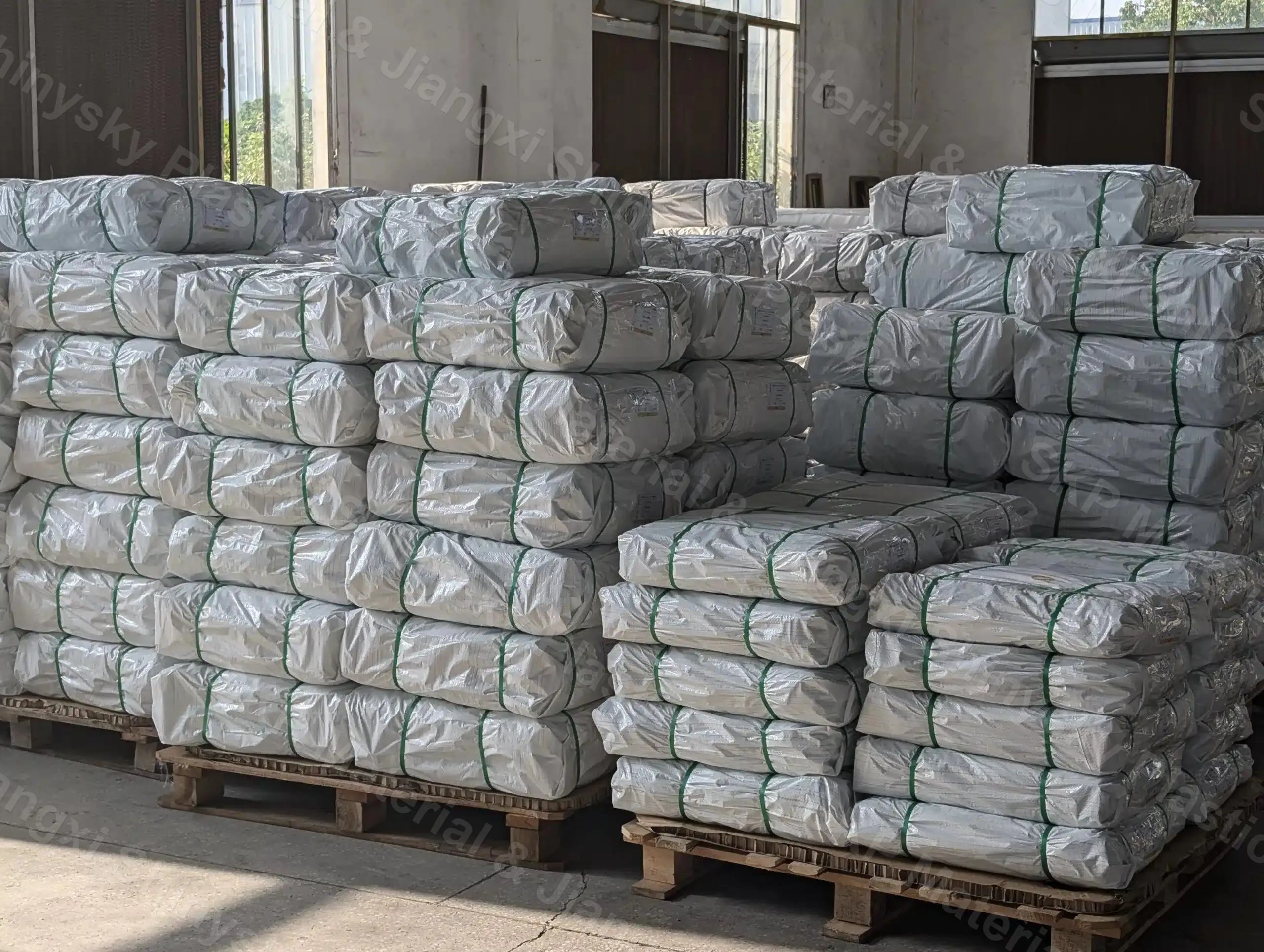 Packed and wrapped bales of PVC mesh stacked for shipment