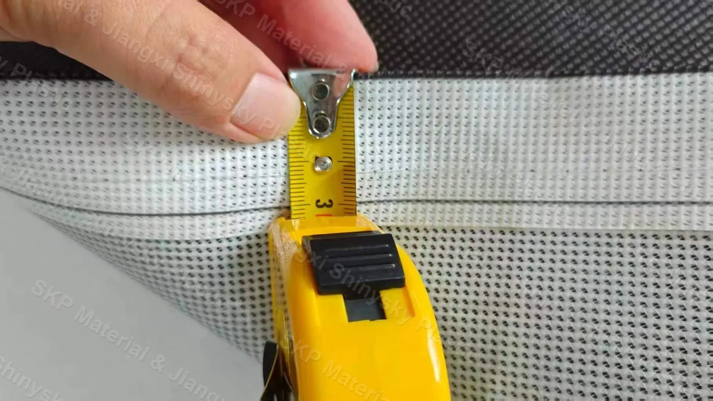 Hemmed edge of PVC mesh banner material being finished at the SKP factory