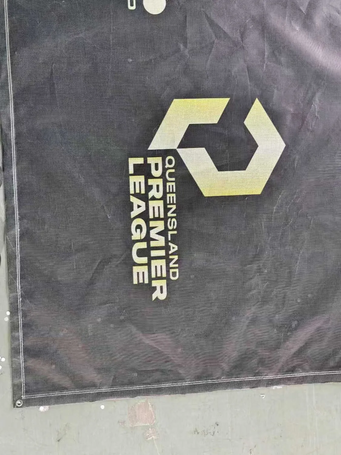 Full-length printed soccer mesh banner laid out on the factory floor before dispatch