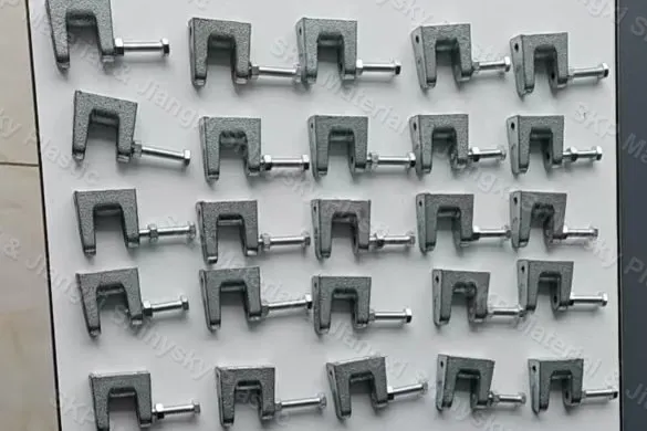 Steel beam clamps with threaded set screws arranged on a display board at the SKP factory